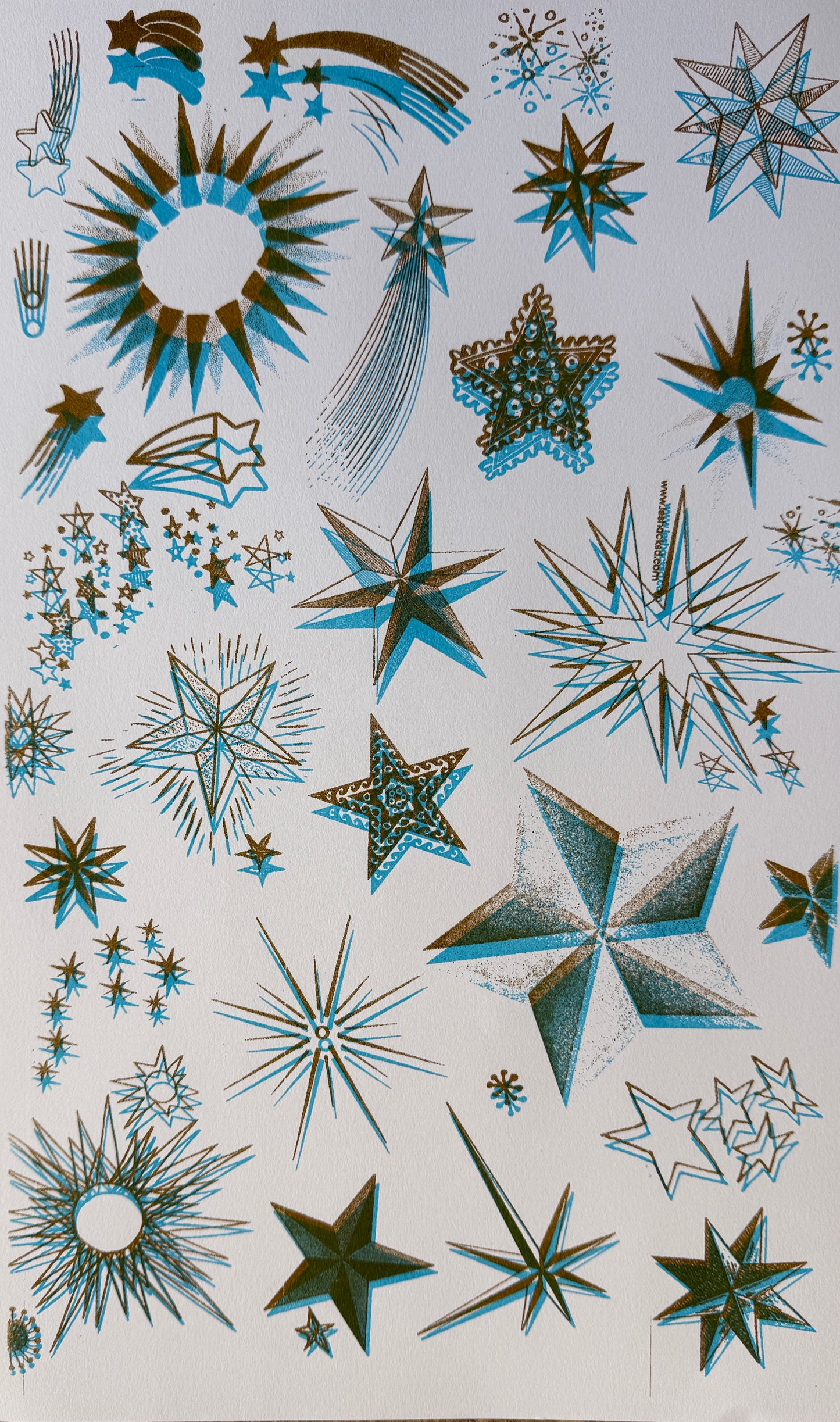 riso print on cardstock of images of stars in layers of ink in aqua and gold ink